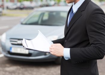 transportation and ownership concept - man with car documents outside