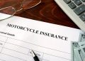 Motorcycle insurance  form and dollars on the table.